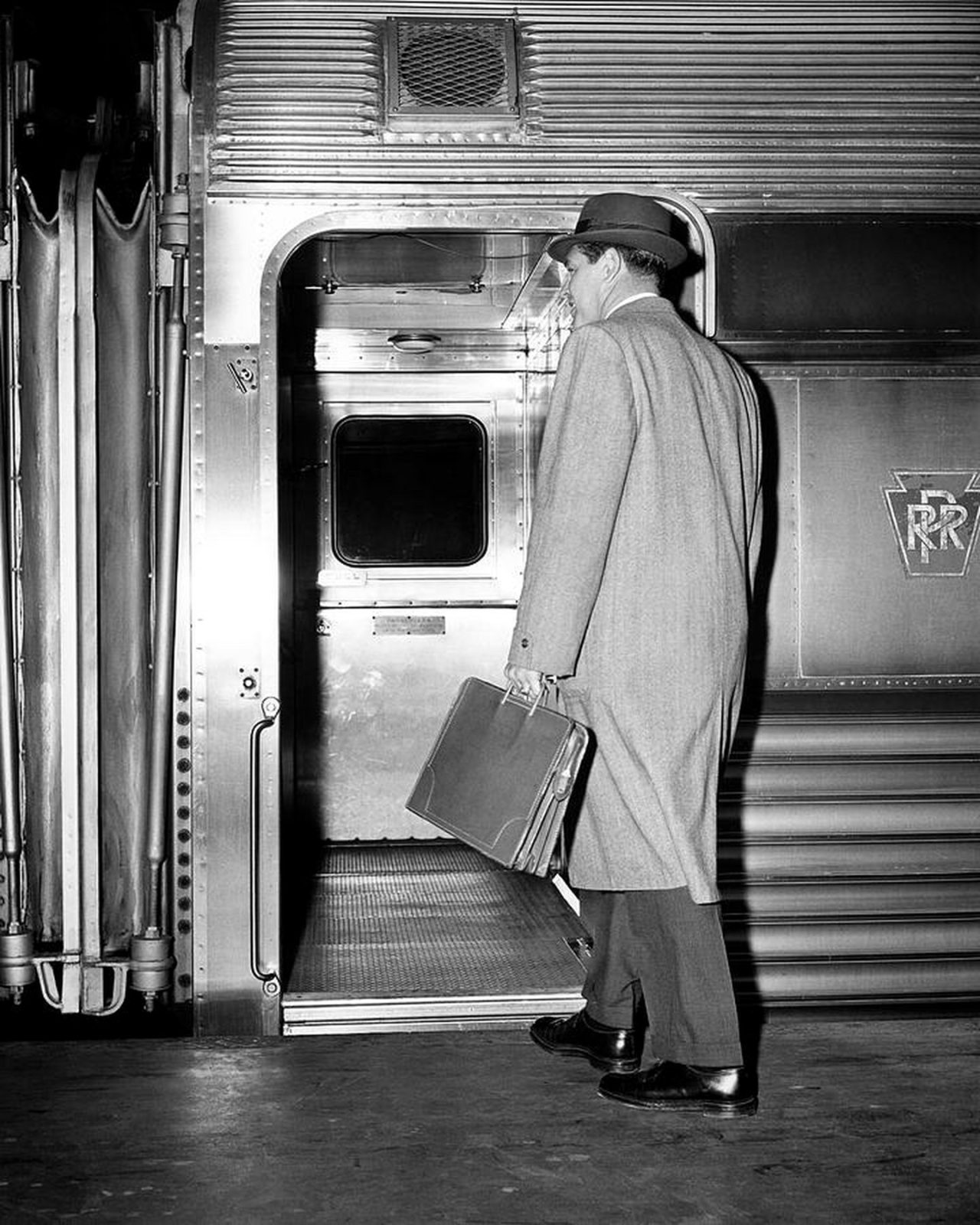 a mid-century businessman with a briefcase boarding a train